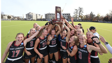 The St. Joe's field hockey team, holds up a trophy as they celebrate their NCAA Final Four berth.